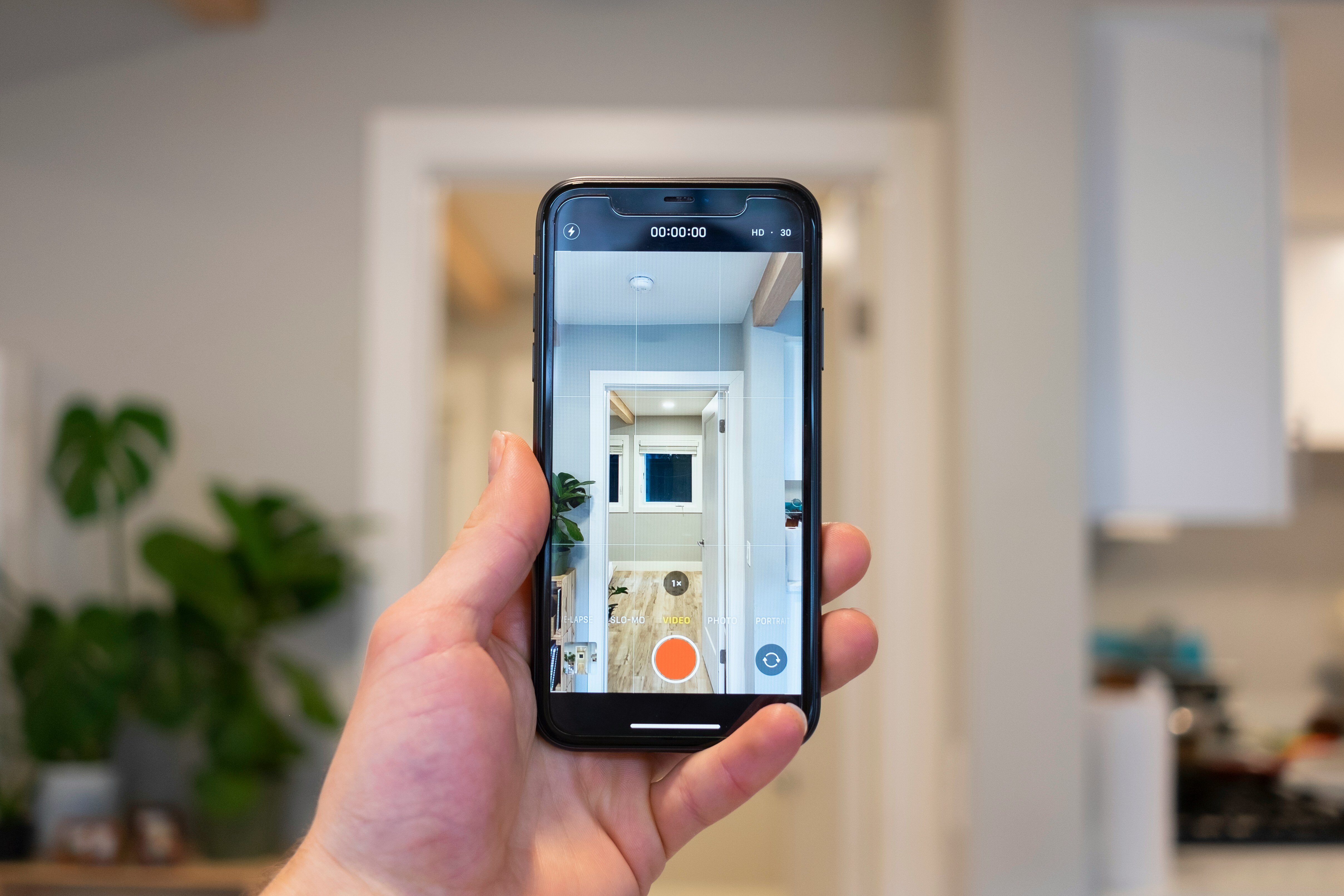 hand holding a phone taking a picture of a modern kitchen